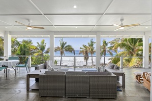 Relax in comfort on the covered lanai, where plush seating and panoramic ocean views create the perfect coastal escape.