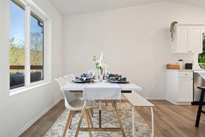 Enjoy intimate meals with lake views at this cozy dining table, where natural light and simplicity enhance every bite.