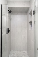 Sleek and modern shower with minimalist design and built-in shelves.