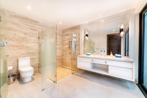 This ensuite bathroom features a large walk-in shower, dual vanities, and modern finishes.