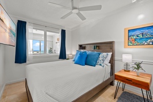 Cozy primary bedroom with plush bedding and scenic city views, designed for restful nights.