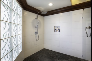 Step into your elegant walk-in shower with rainfall head and premium amenities waiting in the built-in niche.