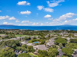 Aerial view of Wailea Ekolu 1106 grounds, surrounded by palms, ocean views, and open skies.