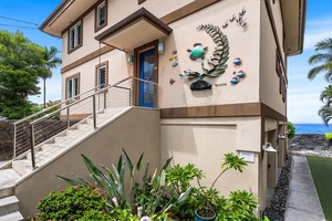 A lava-rock wall and custom sea-turtle plaque signal you’ve arrived at your own private slice of Ali'i Drive—secure, secluded, and steps from the surf.
