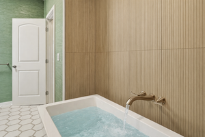 Relax in this luxurious soaking tub where warm water cascades from sleek brass fixtures, creating your perfect spa retreat.
