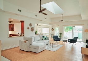 Relax in your spacious living room with vaulted ceilings, skylight, and cozy seating that opens to the kitchen.