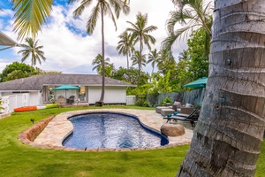 Take a refreshing dip in the pool, surrounded by lush tropical greenery and swaying palm trees.
