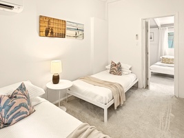 Your peaceful bedroom features twin beds with coastal artwork, creating a serene retreat for restful nights.