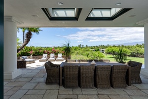 Outdoor dining area with wicker seating and beautiful views of the landscape.