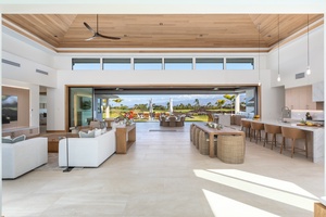 Relax in your stunning open-concept living space where indoor luxury meets outdoor paradise through soaring glass doors.