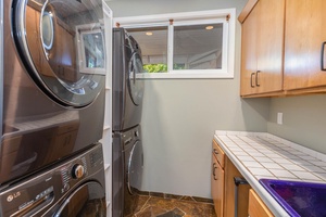Convenient laundry room at Pohaku Villa with washer, dryer, and storage for longer stays.