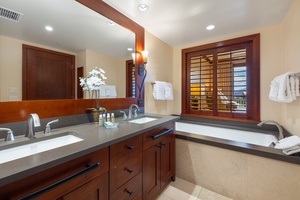 Unwind in the spa-like ensuite with dual vanities, natural finishes, and custom lighting.