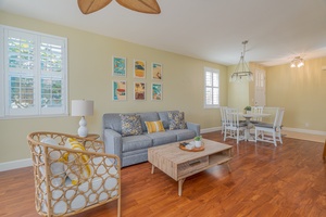 Cozy and bright living room with hardwood floors leading to a welcoming dining area.