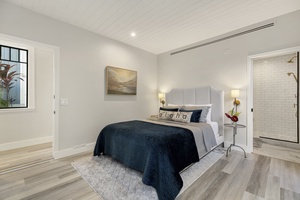 Guest bedroom 5 with queen bed and soft décor, offering a cozy retreat with garden views.