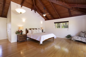 Spacious and airy primary guest suite with a Cal King bed and lofted ceilings.