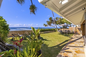 Oceanside yard with outdoor seating with umbrella.