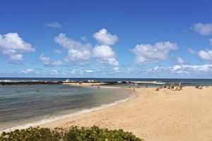 Another view of Poipu Beach with calm waters and sandy shoreline