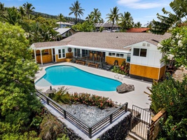 The home and pool spread across the lot, framed by mature palms.