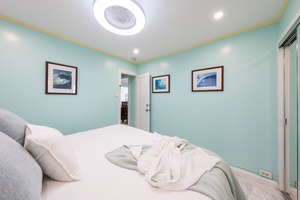 Serene bedroom with soft turquoise walls, ocean-inspired art, and a calming coastal feel.