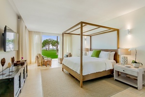 The lower-level secondary suite features four-poster king-sized bed and access to private patio.