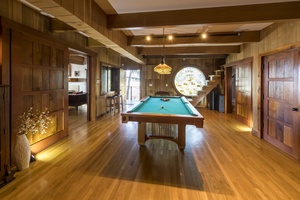 Enjoy a game of pool in this inviting recreation room with warm wooden tones.