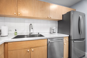 Kitchen area with stainless steel sink and plenty of storage options.