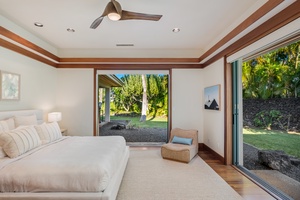 Primary bedroom showcasing lush garden views and natural light. This bedroom sits at the opposite end of the home from the other two guest suites, offering the ultimate in privacy and comfort.