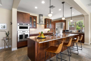 Spacious kitchen island offers plenty of prep space and casual seating for snacks, drinks, or conversation.