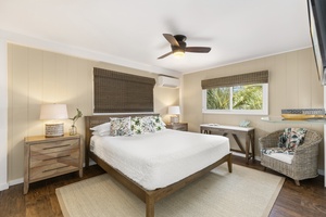 Primary bedroom with California king sized bed and TV.