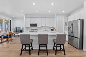 Bright and inviting kitchen with high-top bar seating and direct lanai access.