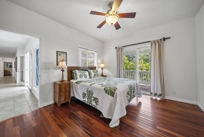 Another view of the airy guest room showcasing hardwood floors and natural light, creating a fresh and inviting retreat.