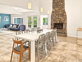 You'll love gathering around this spacious dining table with your group, warmed by the stunning stone fireplace.