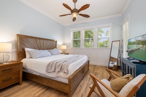 The primary suite offers a luxurious king bed, ceiling fan, and smart TV for the perfect night’s sleep.