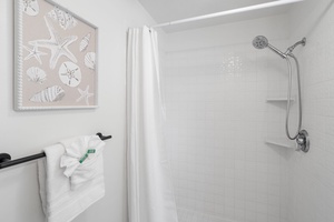 Bright step-in shower in the guest bath offers refreshing convenience after a beach day.