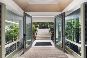 Grand entrance with tropical landscaping and elegant stairway leading to the property.