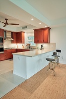Cook your favorite meals in this spacious kitchen featuring rich wood cabinets, sleek countertops, and modern appliances with a breakfast bar for casual dining.