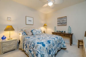 This bedroom comes with a ceiling fan and TV.