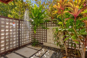 Refresh under the sky in this serene outdoor shower surrounded by lush tropical foliage.