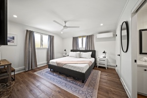 Minimalist suite with a king-sized bed, serene design, and large windows for natural light and breezy comfort.