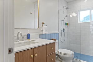 Another angle of the renovated bathroom showcasing clean finishes and bright lighting for a comfortable morning routine.