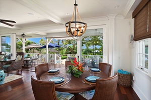 Dining area with garden views and elegant chandelier, ideal for family meals.
