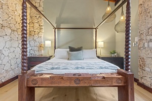 Sleep comfortably in this charming four-poster bed with intricately carved wooden details.