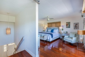 The spacious upstairs primary suite offers a peaceful retreat with split air conditioning and direct access to the adjoining private lanai.