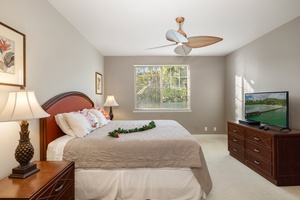 Sink into crisp linens and enjoy your private retreat with tropical touches, modern TV, and garden views through sunny windows.