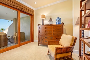 Unwind in a cozy upstairs sitting area with natural light and access to the balcony.
