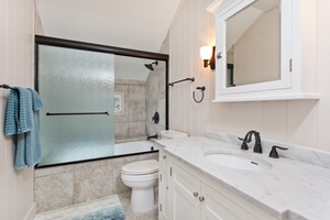 Ensuite primary bathroom with a single vanity and a shower/tub combo.