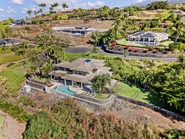 Aerial view of this hillside retreat, showcasing its stunning architecture and pool.