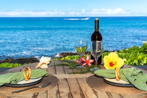 Oceanfront dining spot with bottle of wine and undisturbed seaside views.