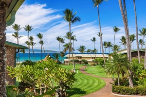 Partial ocean views and blooming plumeria await on the lanai of Napili Shores F-252.