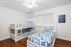 Your coastal-themed bedroom features a bunk bed and twin bed with ocean-inspired linens, perfect for family stays.